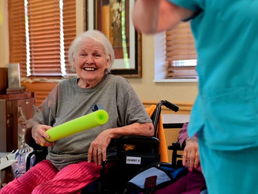 Resident enjoying an activity with staff in a cheerful setting