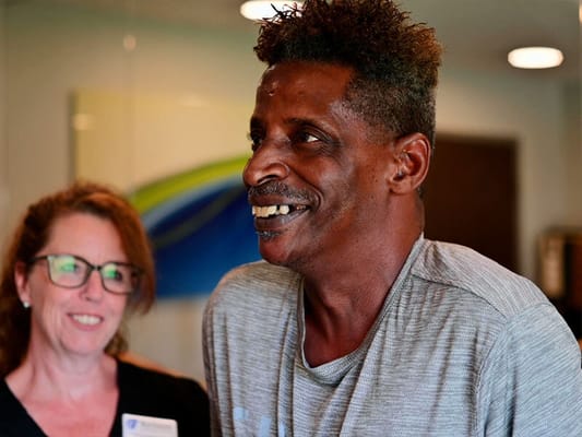 Residents interacting with staff in a bright facility lobby