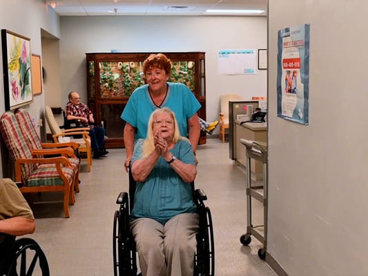 Staff assisting resident in a hallway