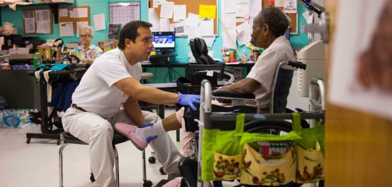 Care staff assisting a resident in an activity room
