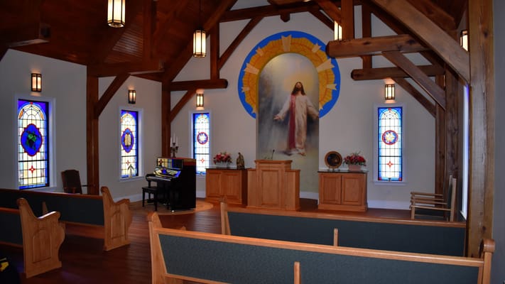 Interior view of a chapel with wooden beams and stained glass