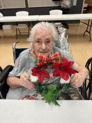 Resident holding a holiday wreath in an activity room