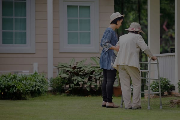 A caregiver assisting a senior resident in the garden