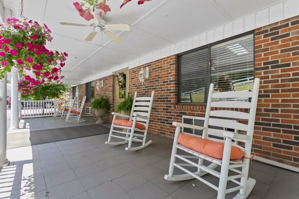 Outdoor porch with rocking chairs and hanging flowers