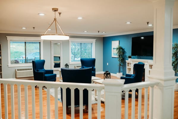 Cozy common area with blue chairs and wooden floors