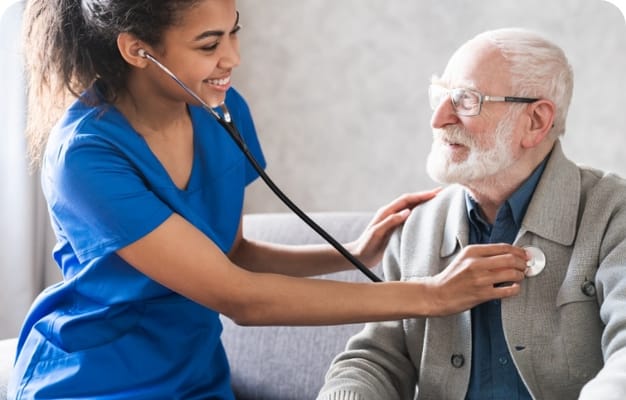 Nurse checking an elderly man's heartbeat