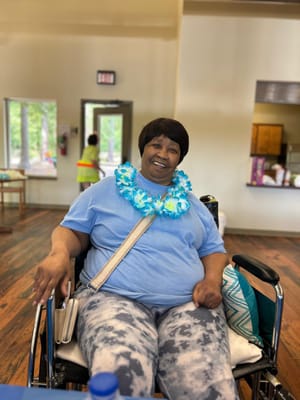 Resident participating in an activity with a floral necklace
