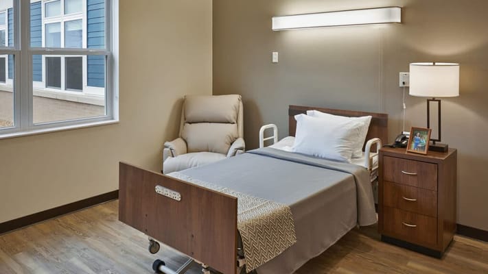 A cozy private room with a bed and armchair