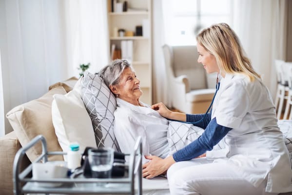 Nurse assisting an elderly woman in a cozy living space