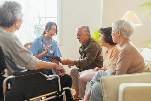 Residents engaged in a discussion with staff in a common area