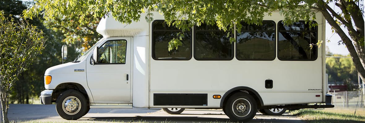 Facility transport vehicle parked under trees