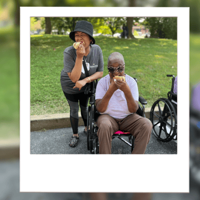 Residents enjoying apples outdoors in wheelchairs