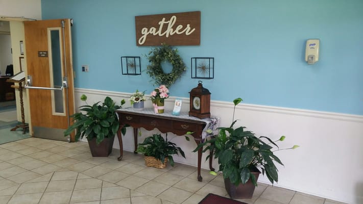 Decorative entryway with plants and welcoming signage