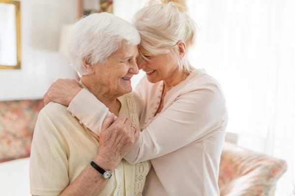 A caregiver hugging a senior resident in a cozy room