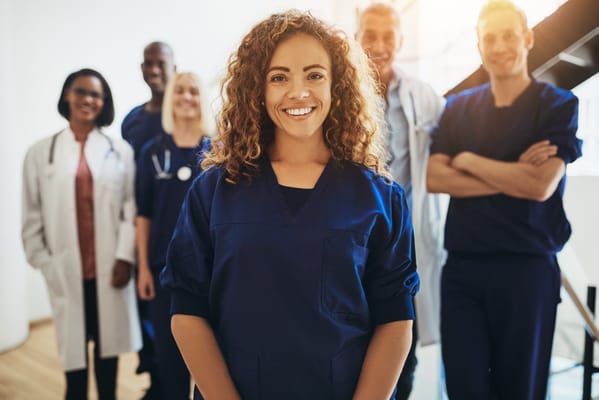 Healthcare staff smiling in a bright hallway