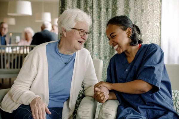 A caregiver and a resident sharing a joyful moment