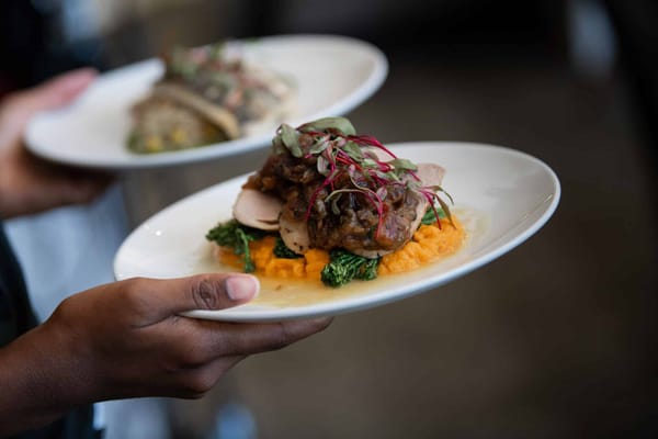 Close-up of a hand holding a gourmet meal