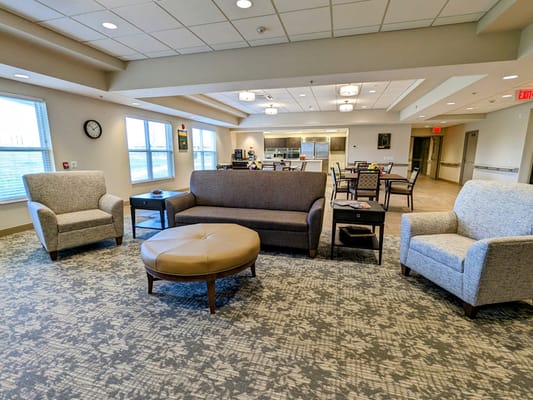Cozy common area with seating and kitchen in background