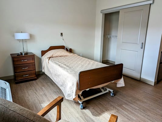 Bright, simple private resident room with a bed