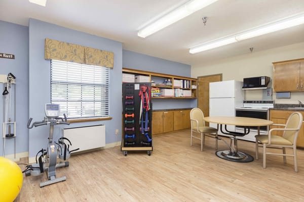 Bright activity room with exercise equipment and seating