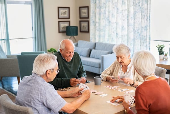 Residents playing cards in a cozy common area