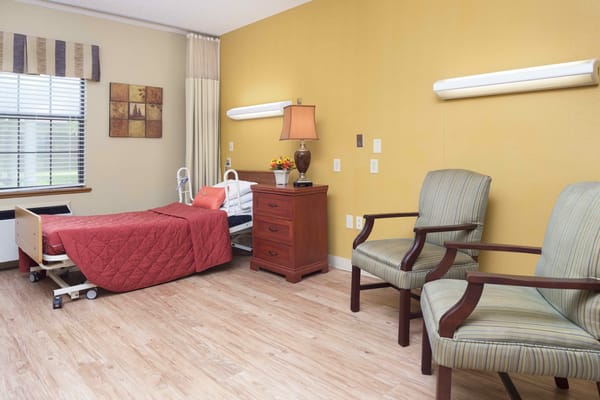 Cozy resident room with a bed and two chairs