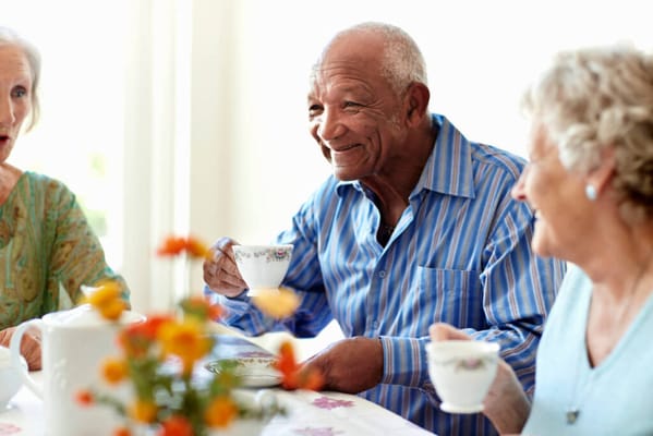 Seniors enjoying tea together at a communal table