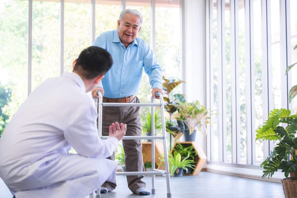 Resident practicing walking with staff support in a bright room