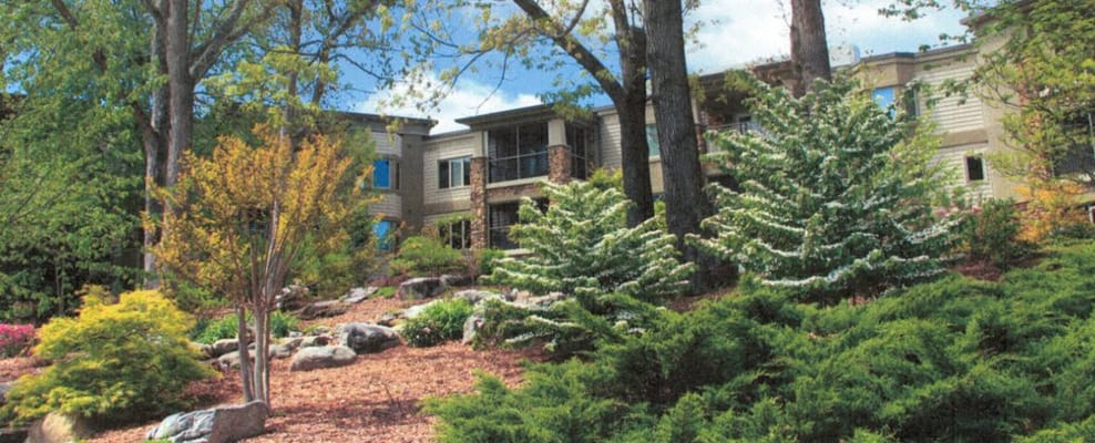 Exterior view of a senior living facility with gardens