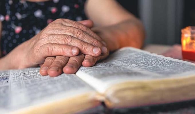 Close-up of hands resting on an open book