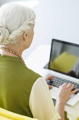 Senior woman using a laptop in a bright room