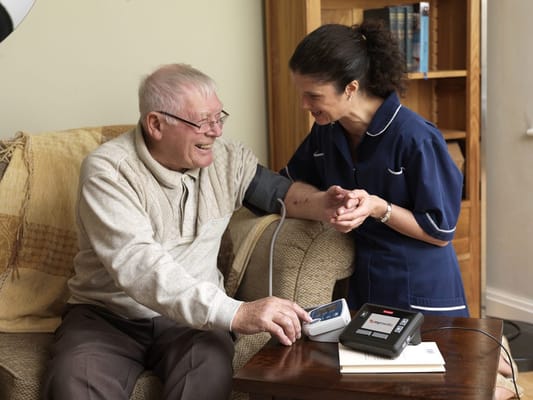 A caregiver taking a resident's blood pressure