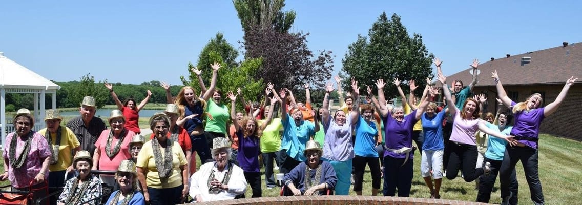 Residents and staff celebrating outdoors with joyful expressions