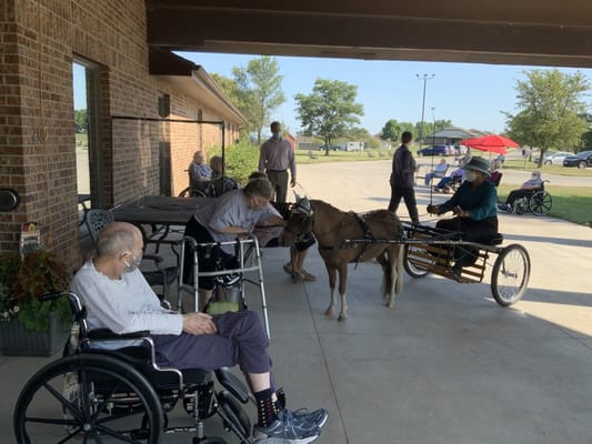 Residents enjoying an outdoor activity with a pony
