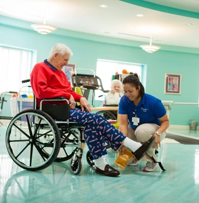 Staff assisting a resident in a bright therapy room