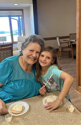 An elderly woman and young girl enjoying snacks together
