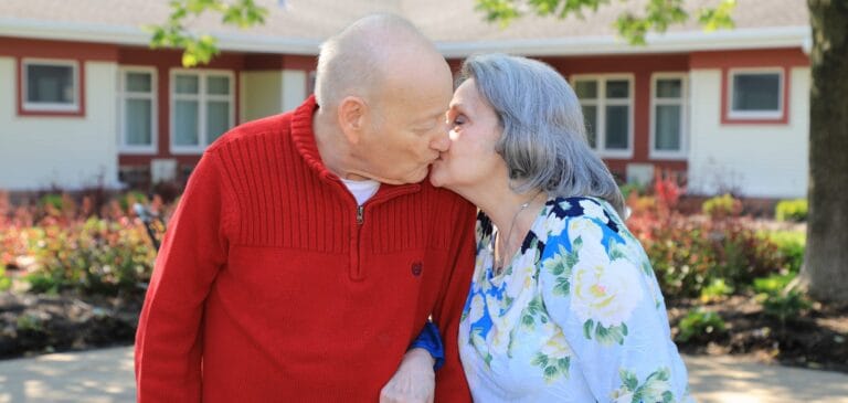 Couple sharing a kiss in a garden setting