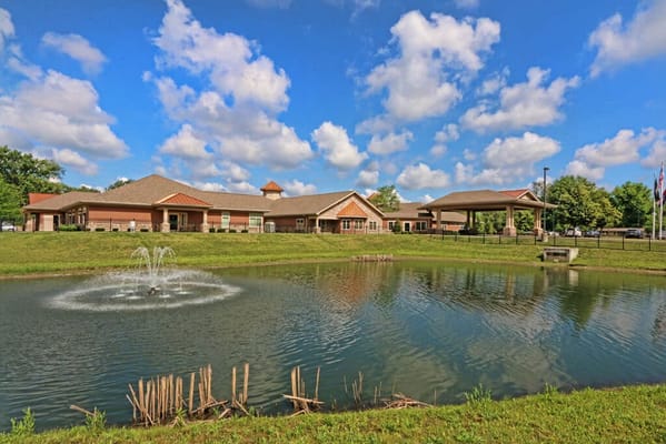 Exterior view of a senior living facility by a pond