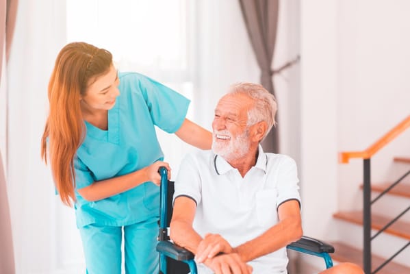 Healthcare worker assisting an elderly man in a bright room