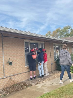 Residents and staff caring for plants outside a facility