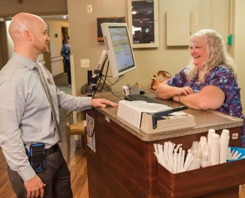 Staff member assisting a resident at the front desk
