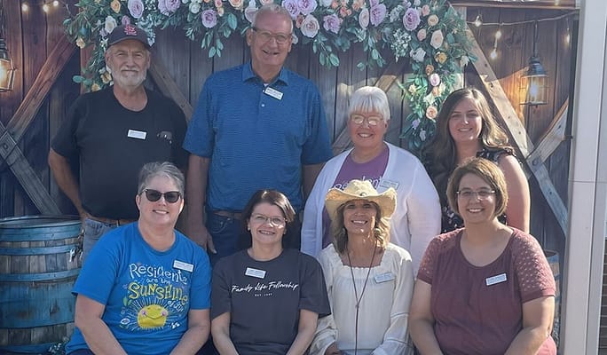 Group photo of staff and residents at a celebration