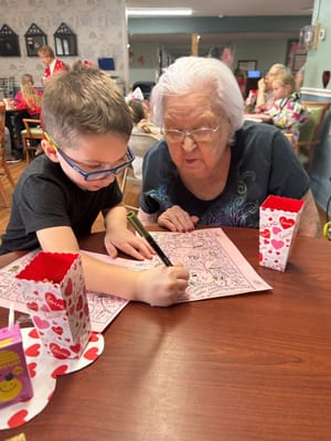 An elderly woman and a child engaging in a coloring activity