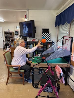Resident playing a game in an activity room