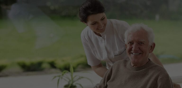 A caregiver assisting a senior man indoors
