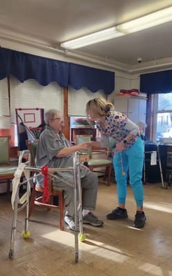A staff member assisting a resident in an activity room