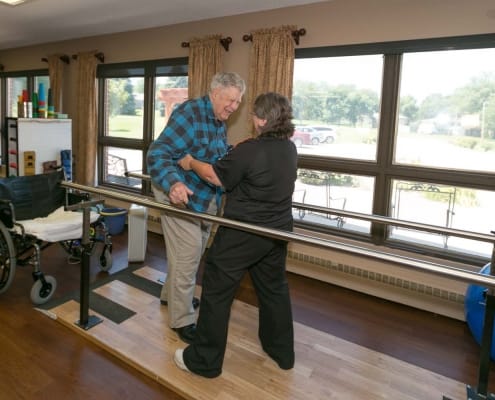Therapist assisting resident with walking exercises indoors