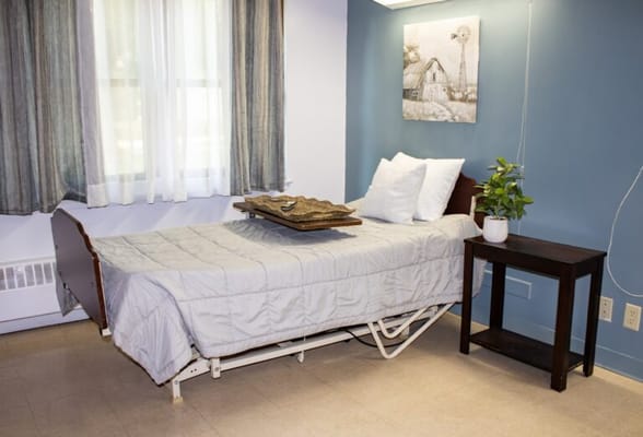 Private resident room with a bed and bedside table