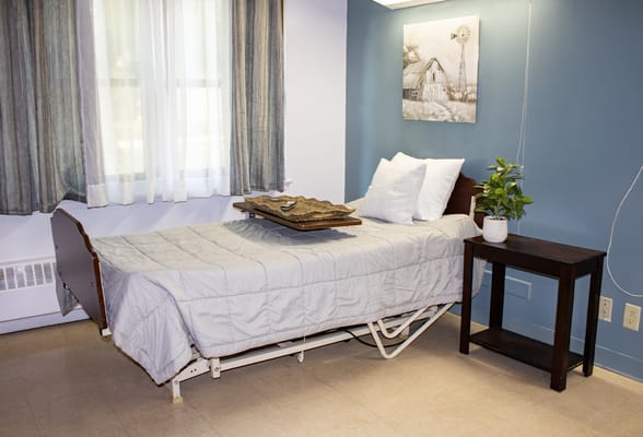 Private resident room with a bed and bedside table