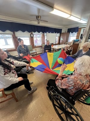 Residents engaging in a fun group activity with a colorful parachute